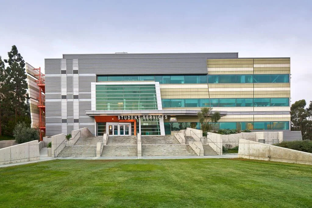 Student Services building with a glass-fronted entrance, broad steps and a ramp to the right.